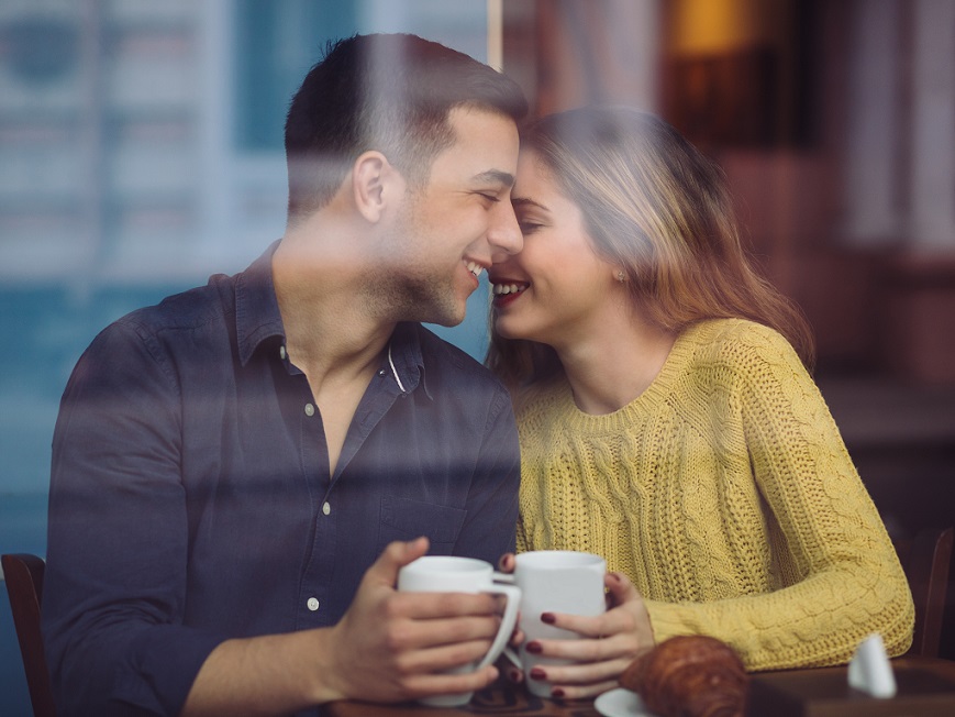 コーヒーショップの幸せな若いカップル