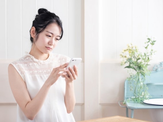 スマホを見て困る女性