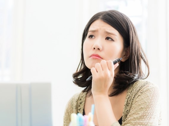 パソコンの前で悩む女性